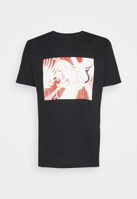 Sort kortærmet T-shirt med en stor firkantet grafik af en hvid kran med en rød og pink abstrakt baggrund på forsiden.