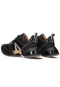 Sneakers nere con tomaia sintetica liscia, dettagli metallici dorati, suola robusta e linguette sul tallone. Dettagli testurizzati in tutto il modello.
