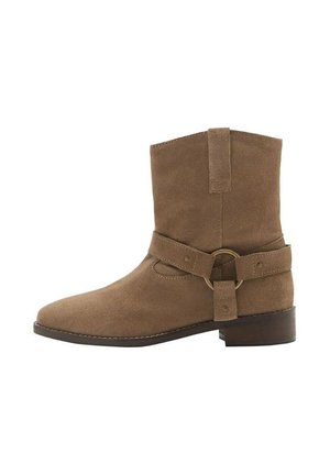 Stivaletto in suede marrone con punta rotonda, gambale corto e una fascetta regolabile con un anello metallico attorno alla caviglia. Tacco basso a blocco.