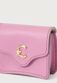 Small textured pink leather wallet with a gold interlocking "C" clasp and contrast stitching on light background.