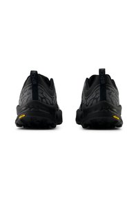 Černé sportovní boty s texturovaným svrškem, zesílenou patou a podešví Vibram. Lehký design s poutky pro snadné obouvání.