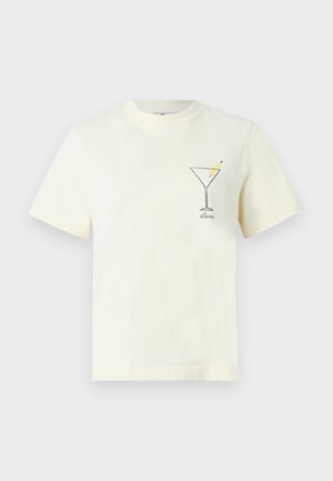 Krém színű rövid ujjú póló, a bal mellrészen egy kis fekete kontúrú martini pohárral és két sárga olívabogyóval.