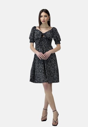 Schwarzes Kleid mit Blumenmuster, Puffärmeln und einer Bindeschnur am Ausschnitt. A-Linien-Silhouette mit knielanger Saum.