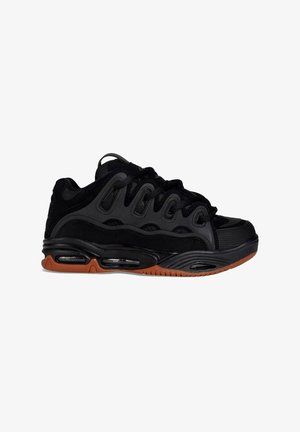 Zapatillas deportivas negras con parte superior de malla texturizada, suela de goma, amortiguación de aire visible y suela de goma para mayor tracción.