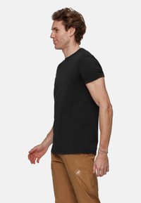 Zwarte T-shirt met korte mouwen en ronde hals, gemaakt van katoen. Beschikt over een klein rood logo op de borst. Klassieke pasvorm.