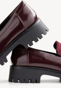 Pantofi din piele lacuită burgundă, cu un vamp texturat și o talpă chunky neagră, având vârful rotund și detalii minime de cusătură.