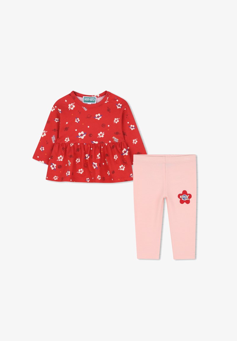 Haut à manches longues rouge à fleurs avec taille froncée et leggings roses avec un patch logo. Matériau en coton, design ludique avec des accents colorés.