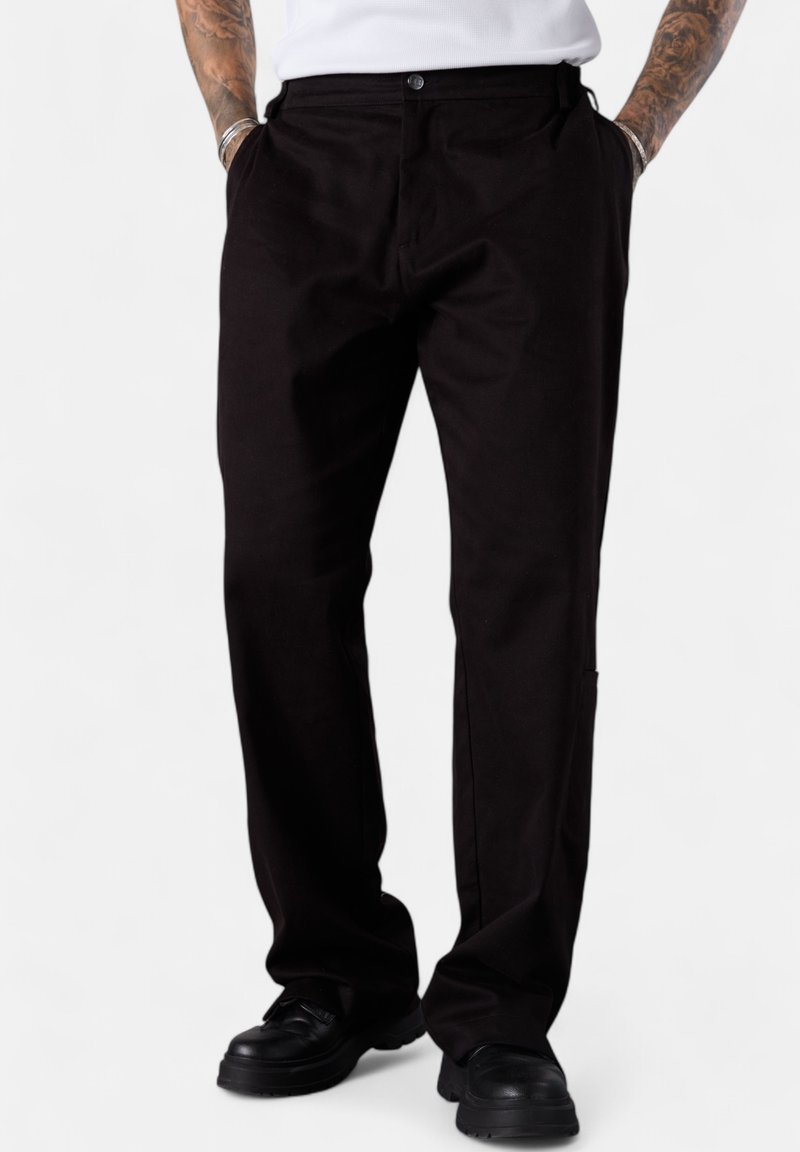 Black cotton trousers with a straight fit, featuring front pockets and a button closure. Textured fabric with a smooth finish. Casual style.