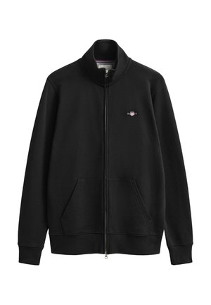 Musta vetoketjullinen collegepaita pystykauluksella, sivutaskuilla, resorivuoratuilla hihansuilla ja vasemmassa rinnassa pienellä kirjotulla logolla.