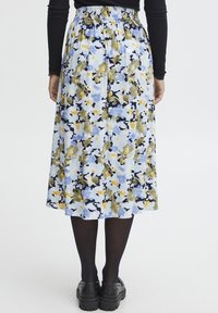 Blommig midikjol i ljusblått, med mönster i grönt, gult och mörkblått, med elastisk midja och subtil textur.