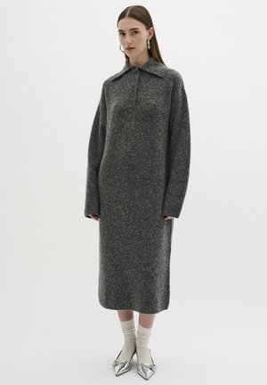 Robe tricotée grise avec col, manches longues et silhouette droite, associée à des ballerines argentées pointues et des chaussettes de couleur claire.