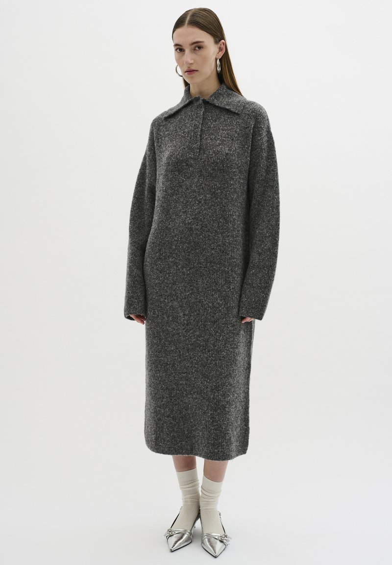 Abito a maglia grigio con colletto, maniche lunghe e silhouette dritta, abbinato a ballerine argentate con punta e calzini chiari.