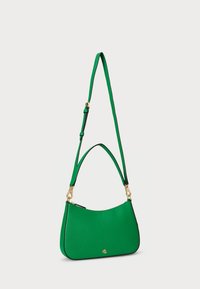 Žalia dirbtinė rankinė, turinti kreivą formą, auksinius akcentus, reguliuojamą dirželį ir logotipo detalę priekyje. Lygus paviršius.