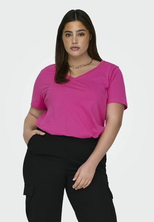 Fuchsia v-hals t-shirt gemaakt van zachte stof, met korte mouwen en een relaxte pasvorm, gecombineerd met zwarte cargobroek.