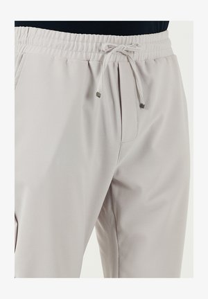 Pantalones jogger de color gris claro, hechos de una tela texturizada, con cintura elástica, cierre de cordón y detalles de bolsillos laterales.