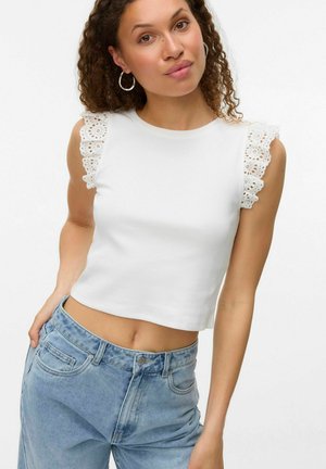Witte katoenen crop top met ingewikkelde kantafwerking op de schouders. Gecombineerd met lichtblauwe denim high-waisted jeans. Eenvoudig, schoon ontwerp.