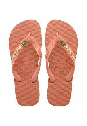 Infradito in gomma rosa con fondo testurizzato, design con fascia larga e logo del marchio sulla fascia. Presenta un sottile accento con la bandiera brasiliana.