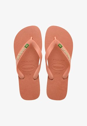 Infradito in gomma rosa con fondo testurizzato, design con fascia larga e logo del marchio sulla fascia. Presenta un sottile accento con la bandiera brasiliana.