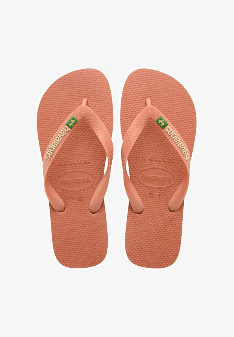 Infradito in gomma rosa con fondo testurizzato, design con fascia larga e logo del marchio sulla fascia. Presenta un sottile accento con la bandiera brasiliana.