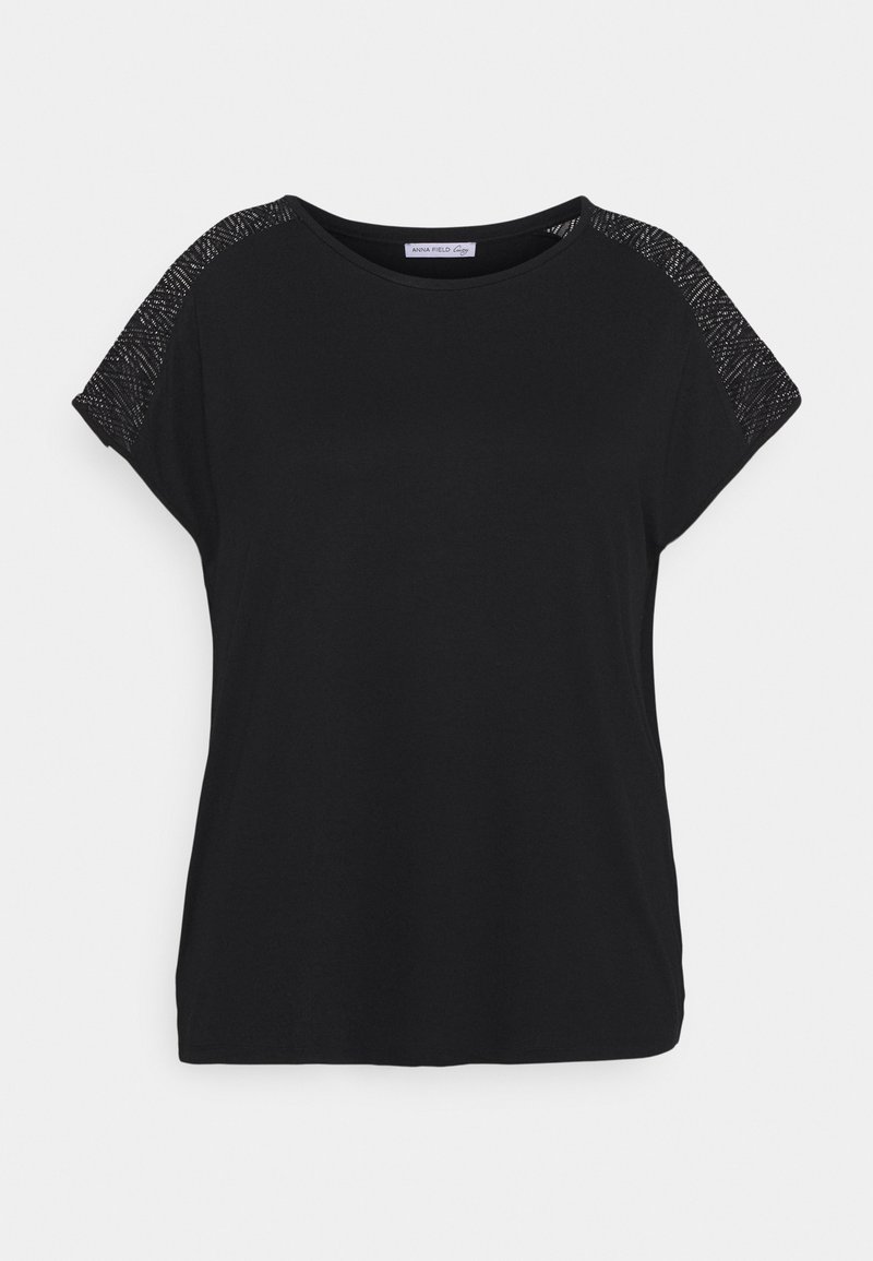 Camiseta negra de manga corta con escote redondeado y panel de malla texturizada en los hombros, confeccionada en suave tejido de punto.