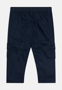 Marinblå cargoshorts med elastisk midja, två bakfickor och sidofickor förlastning. Slät tyg med platta sömmar och sömdekoration.