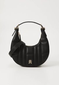 Mustast nahast õlakott ümmarguse, polsterdatud disainiga, millel on kuldse tooniga logo, reguleeritav rihm ja läikivad riistvaralised detailid.