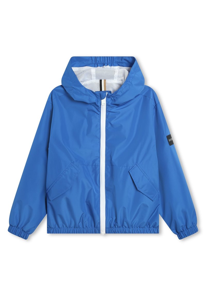 Giacca a vento blu con cappuccio, polsini elastici, tasche frontali e una cerniera bianca; presenta un rivestimento in rete con un dettaglio a righe.