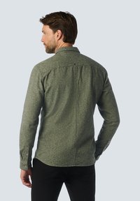 Groene overhemd met een gestructureerde stof, voorzien van een achternaaddetail en lange mouwen, gecombineerd met donkere broeken.