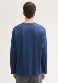 Lange mouwen blauwe shirt van een zachte stof, met een ronde halslijn en een relaxte pasvorm. Geen zichtbare patronen of accenten.