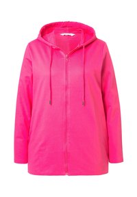 Haut à capuche zippé rose avec une capuche à cordon, des manches longues et une texture lisse. Le design comprend une fermeture éclair à l'avant et une coupe décontractée.