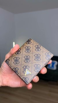 Bruine portemonnee van textuurmateriaal, met een geometrisch logo, patroonontwerp en een driehoekige gouden accent aan de voorkant.