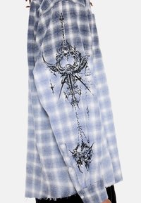 Φόρεμα με μακριά μανίκια σε φωτεινό γαλάζιο και άσπρο καρό, με μαύρο περίτεχνο λουλουδάτο και μυτερό σχέδιο γραφικών στο μανίκι, που δείχνει ξεφτισμένο τελείωμα.