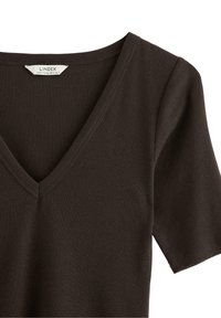 Top a coste in maglina di cotone marrone scuro con scollo a V e maniche corte. Presenta una texture sottile e un'etichetta con le informazioni sul marchio vicino al colletto.