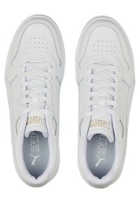Vitaidrottsskor i vit färg med en slät överdel i syntetläder, snörning, perforerad tåbox och subtila ljusgrå detaljer. Gul logotyp på tungan.