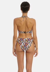 Bikini set met halternek. Bevat een meerkleurig geometrisch patroon op rekbare stof. De achterkant heeft een sluiting en strikken.