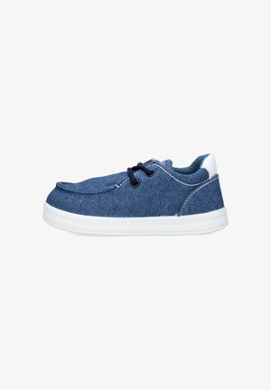Sneaker casual basse in tessuto denim blu con lacci neri, suola in gomma bianca e linguetta bianca sul tallone, vista laterale su sfondo bianco.