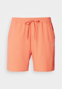 Shorts de bain texturés corail avec taille élastique, cordon de serrage réglable, poches latérales et petit logo brodé blanc sur la cuisse droite.
