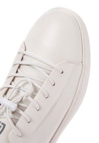 Sneaker in pelle bianca con punta arrotondata, lacci piatti e dettagli perforati. Presenta una texture liscia e un logo discreto vicino alla suola.