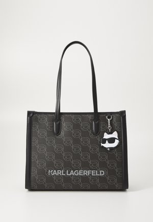 Sac tote noir Karl Lagerfeld avec motif de logo répété, longues anses et breloque chat portant des lunettes de soleil attachée à une anse.