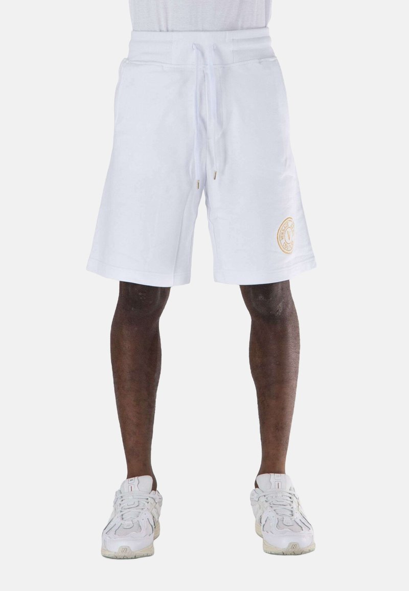 Pantaloni corti bianchi di lunghezza media con vita regolabile tramite cordoncino e dettaglio del logo ricamato in oro sulla gamba sinistra. Tessuto in misto cotone con una consistenza liscia.