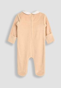 Combinaison en velours beige doux avec des manches longues, un col blanc et une fermeture à boutons pressions au dos. Présente des manches à revers et un design avec pieds.