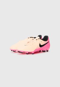 Fotbalové kopačky Nike v světle růžové barvě s černými akcenty a šňůrkami, vybavené texturovanou podešví a jasně růžovými kolíky.