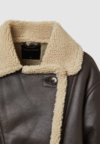 Giacca di pelle marrone con colletto in finta pelliccia beige, dotata di chiusura a bottone e finitura texturizzata. Etichettata "CALLIOPE", taglia S.