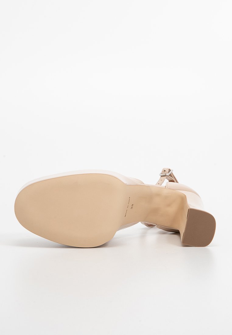 Beige High-Heel-Schuh mit einem glatten Lederoberteil, Knöchelriemen und einer abgerundeten Zehe. Die Sohle ist stabil mit einer dezenten Textur.