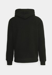 Felpa con cappuccio nera in pile con superficie testurizzata, maniche lunghe, polsini a costine e cappuccio, mostrata da dietro su uno sfondo bianco.