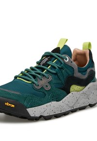 Sneaker turchese e nera con tessuto strutturato, dettagli grigi e suola bianca maculata. Presenta tocchi di verde e lacci multicolore.