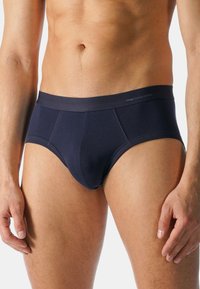 Navy puuvillatrussi, jossa on tiukka istuvuus, litteä vyötärö ja kontrastivärisetompeleet. Korkea laatu ja minimaalinen brändäys vyötäröllä.