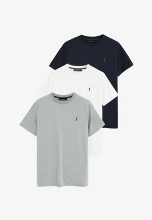 Tres camisetas de manga corta con cuello redondo en negro, blanco y gris, cada una con un pequeño logo bordado de un jugador de polo en el pecho izquierdo.