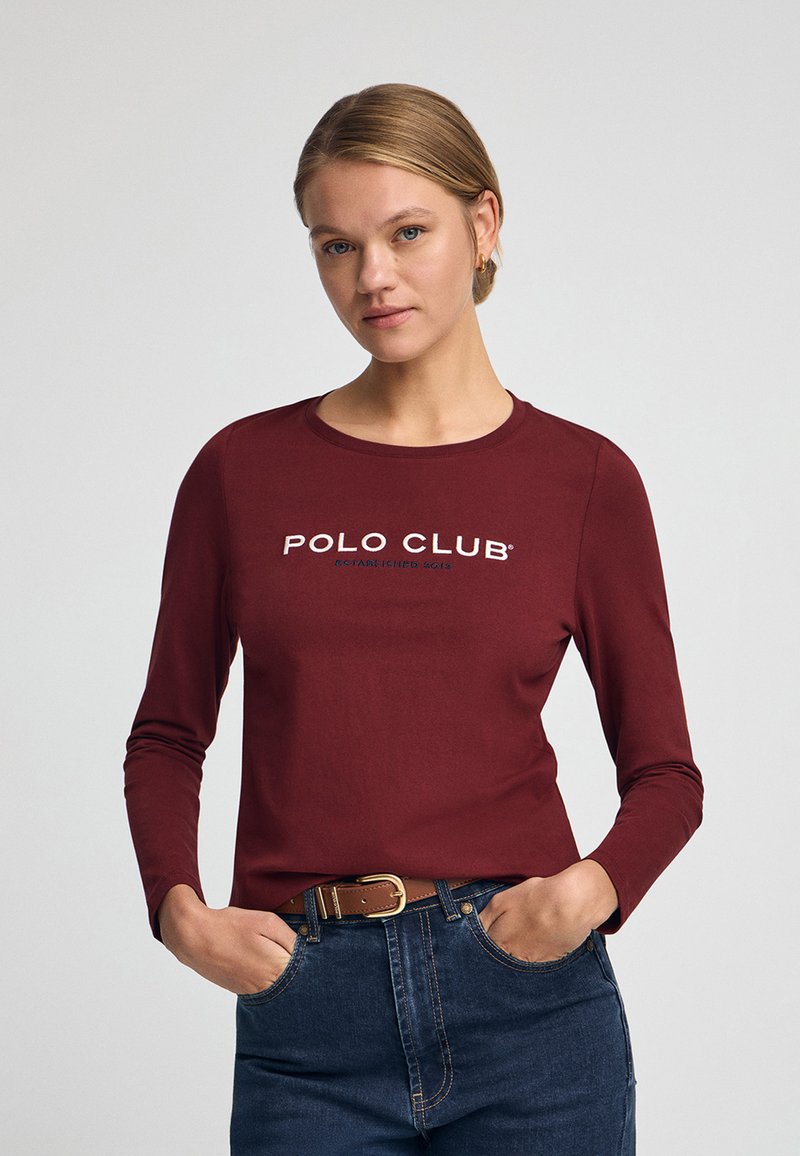 Långärmad burgundy skjorta med "POLO CLUB"-logotyp i vitt, tillverkad av mjukt tyg, med rund hals och avslappnad passform.