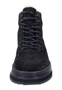 Černé semišové kotníkové bootky s kulatou špičkou, černými tkaničkami, texturovanou podrážkou a měkkým umělým kožešinovým podšíváním na vrchu.